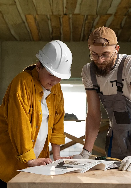Ev yenileme uzmanları, proje planlarını gözden geçirip inşaat ve yeniden modelleme çalışmalarını tartışıyor.